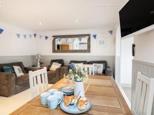 a living room with a wooden table with food on it at Offshore in Porthtowan