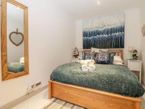a bedroom with a bed with a large mirror at Offshore in Porthtowan