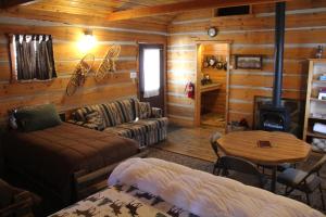 a log cabin living room with a couch and a stove at Sugar Loaf Lodge & Cabins in Anaconda