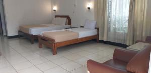 A bed or beds in a room at Intan Hotel Purwakarta