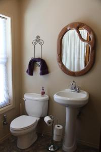 a bathroom with a toilet and a sink and a mirror at Sugar Loaf Lodge & Cabins in Anaconda +36 photos