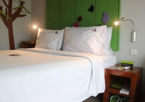 a bedroom with a white bed and a green wall at MaxOneHotels.com at Sabang in Jakarta