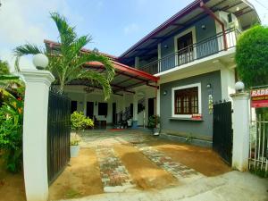 a house with a gate and a courtyard at Radha Tourist Home in Polonnaruwa