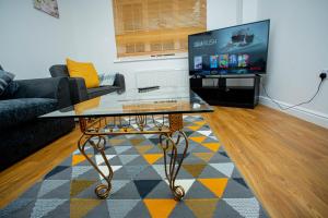 a living room with a coffee table and a tv at Somerset Place in Northampton