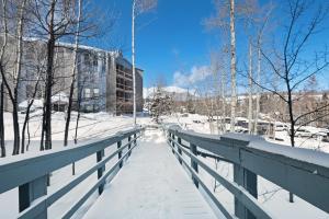 a bridge in the snow with a building in the background at Lodgepole Condos in Silverthorne