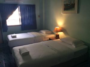 a hotel room with two beds and a window at J-2 Court in Songkhla