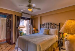 a bedroom with a bed and a ceiling fan at Los Robles Charming Colonial Boutique Hotel in Managua