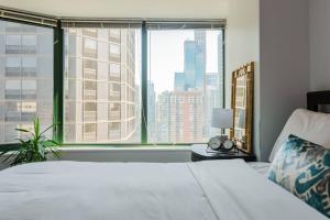 een slaapkamer met een bed en een groot raam bij ENVITAE Luxury Sky Loft Indoor Pool & Gym in Chicago