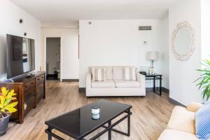 uma sala de estar com um sofá branco e uma mesa de centro em ENVITAE Luxury Sky Loft Indoor Pool & Gym em Chicago