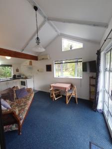 een woonkamer met een bank en een tafel bij Poripori Homestead in Tauranga