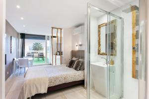 sypialnia z łóżkiem oraz łazienka z umywalką w obiekcie Java Heliopolis naturiste w Cap d'Agde