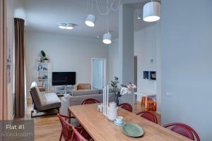 a living room with a dining room table and a couch at Dandelion Apartments Matīsa in Rīga