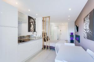 biały apartament z sypialnią i łóżkiem w obiekcie Java Heliopolis naturiste w Cap d'Agde