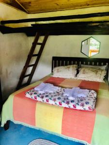 Cama en habitación con escalera en la pared en Solar Picu Eco-hospedaria en Itamonte