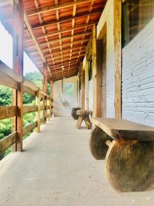 una fila de bancos de madera en un edificio en Solar Picu Eco-hospedaria en Itamonte