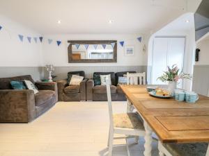 a living room with a table and a couch at Offshore in Porthtowan