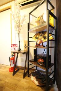 Zimmer mit Bücherregal und Tisch mit Lampe in der Unterkunft TRAD GUEST HOUSE KYOTO Kyomachiya in Kyoto