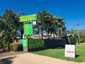 un cartello di un motel di fronte a una casa con palme di Emerald Highlands Motel a Emerald