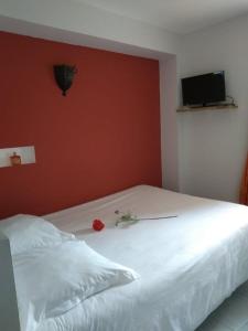 a bedroom with a white bed with a red wall at La Dame de Messignac in Ternand