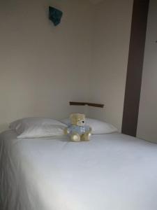 a teddy bear sitting on top of a bed at La Dame de Messignac in Ternand