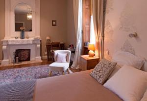 una camera con letto, sedia e camino di Manoir Tregont Mab a Quimper