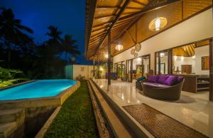 una casa con piscina en el patio trasero en Axros Villa, en Ubud