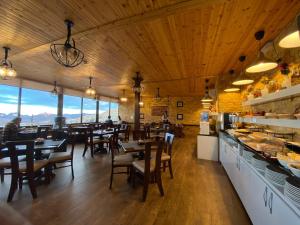 a restaurant with wooden ceilings and tables and chairs at Town Season Hotel in Wadi Musa