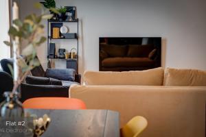 a living room with two couches and a table at Dandelion Apartments Matīsa in Riga