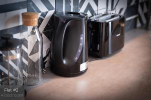 a group of coffeemakers and coffee pots on a counter at Dandelion Apartments Matīsa in Riga