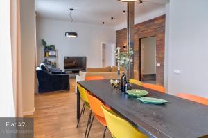 a dining room and living room with a table and chairs at Dandelion Apartments Matīsa in Riga