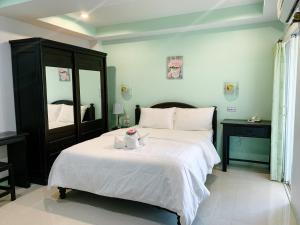 J Jamroon Place في ناخون راتشاسيما: غرفة نوم بسرير ابيض كبير ومرآة