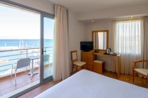 ein Hotelzimmer mit einem Schlafzimmer mit Balkon in der Unterkunft Cabo Verde Hotel in Mati