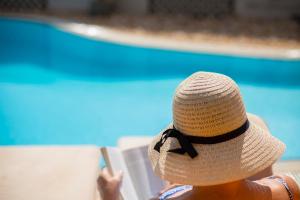 a person wearing a straw hat reading a book at Cabo Verde Hotel in Mati