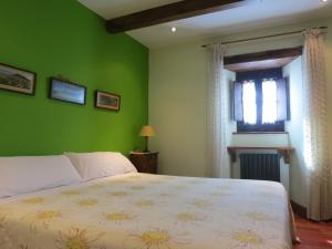 Dormitorio verde con cama y ventana en Herranetxe, en Bóveda