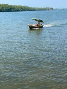 zwei Personen in einem Boot auf einem Wasserkörper in der Unterkunft Amri River Cottages And Ayurvedee Retreat in Bentota