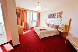 a hotel room with a bed and a red carpet at Jolly Hotel in Lezhë +29 photos