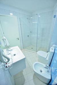 a bathroom with a toilet and a sink and a shower at Jolly Hotel in Lezhë