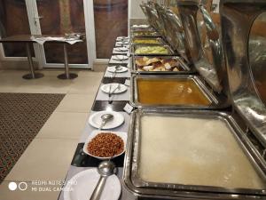 a long buffet line of food in a restaurant at Maya Heritage in Bodh Gaya