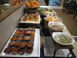 a buffet of food with cupcakes and other foods at Maya Heritage in Bodh Gaya