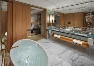 a bath room with a tub and a sink at Mandarin Oriental Jumeira, Dubai in Dubai