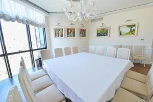a dining room with a white table and chairs at Jolly Hotel in Lezhë