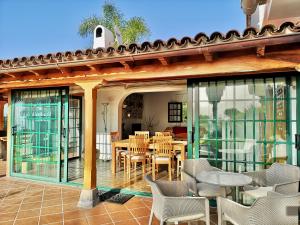 a patio with tables and chairs on a house at Nanou House in La Matanza de Acentejo