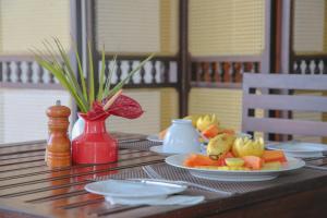 a table with plates of fruit on top of it at Sea World Boutique Hotel in Mirissa