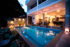 a swimming pool in front of a house at night at Sea World Boutique Hotel in Mirissa