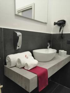 łazienka z umywalką i blatem z ręcznikami w obiekcie Cabà bed&breakfast w mieście Napoli