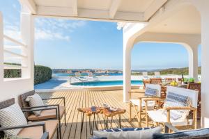 patio con sedie, tavolo e piscina di Villa Pilar a Es Mercadal