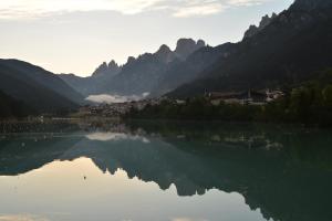 vistas a un lago con montañas en el fondo en Hotel Panoramic, en Auronzo di Cadore