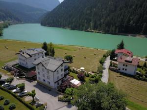 an aerial view of a house next to a lake at Hotel Panoramic in Auronzo di Cadore
