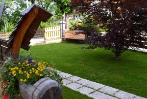 um jardim com um banco de madeira e algumas flores em Hotel Panoramic em Auronzo di Cadore