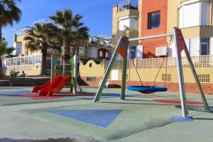 einen Spielplatz mit Rutsche und Schaukel in der Unterkunft VILLA LUNA Beach Premium 9PAX in Torre de Benagalbón